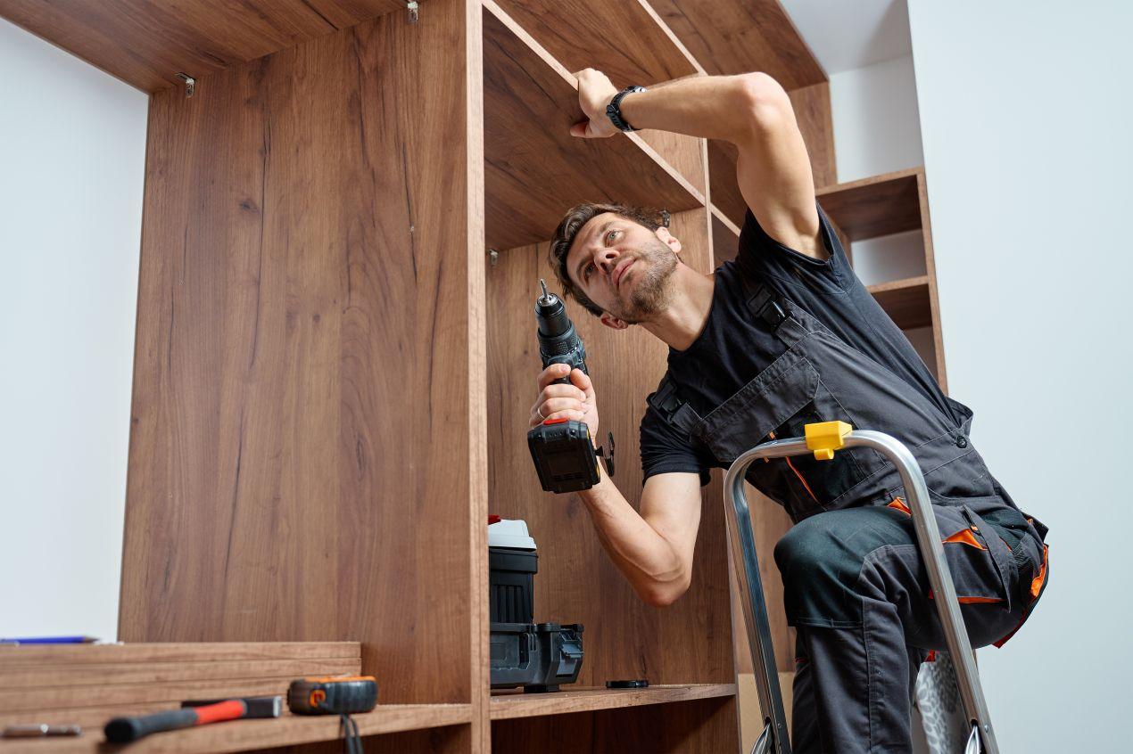 Tischler montiert individuell geplanten Einbauschrank im Rahmen eines moebelbau berlin Projekts in einer Stadtwohnung